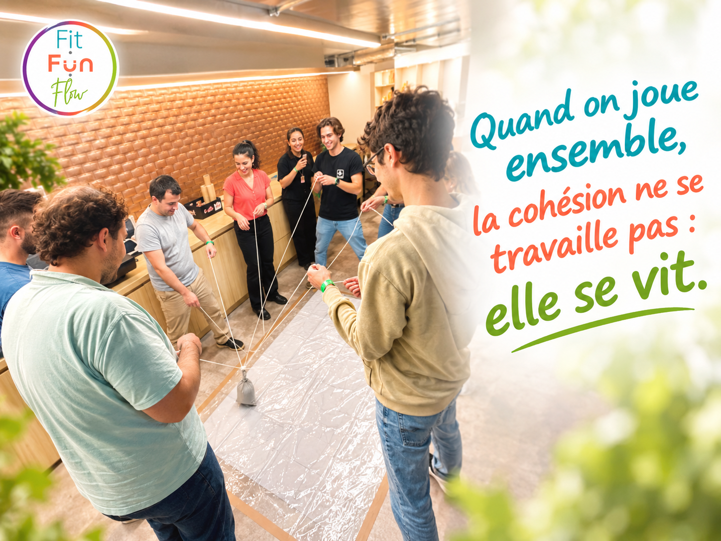Des collègues tiennent ensemble des ficelles pour déplacer un objet au sol : quand on joue ensemble, la cohésion ne se travaille pas, elle se vit.